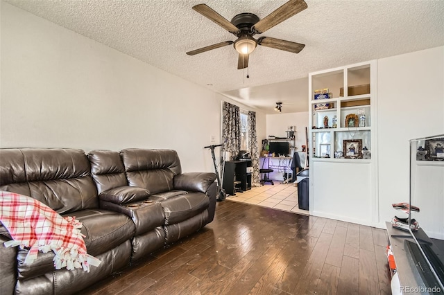 living room with hardwood / wood-style flooring, a ceiling fan, and a textured ceiling