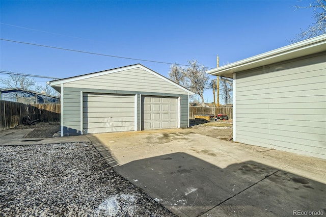 detached garage featuring fence