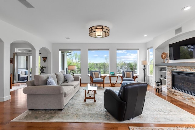living room with wood finished floors, recessed lighting, a fireplace, and baseboards