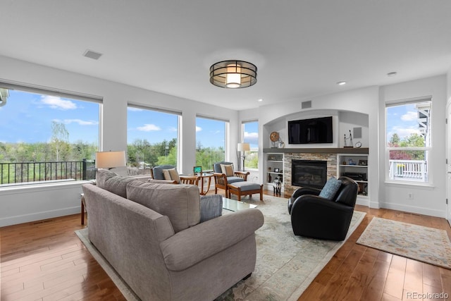 living area featuring a fireplace, baseboards, healthy amount of natural light, and recessed lighting