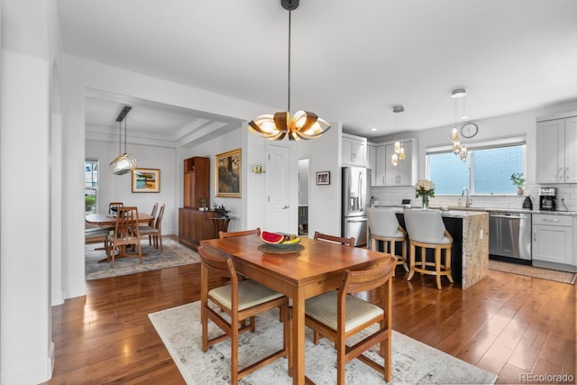 dining space featuring plenty of natural light, wood-type flooring, and a chandelier