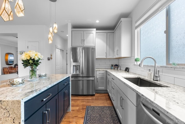kitchen featuring stainless steel appliances, recessed lighting, a sink, light wood-type flooring, and backsplash