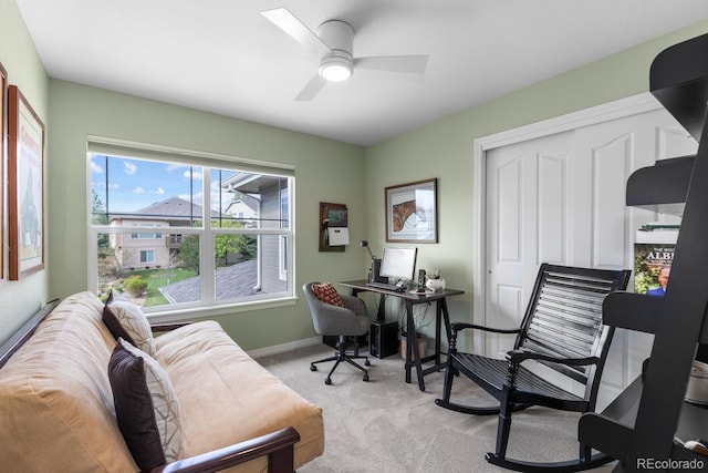 office space with light colored carpet, ceiling fan, and baseboards