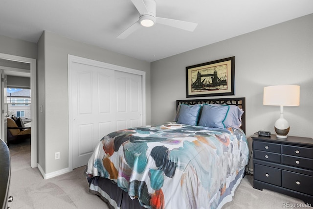 bedroom featuring light colored carpet, a closet, ceiling fan, and baseboards