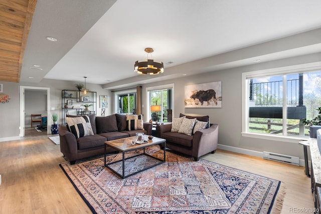 living room with a baseboard heating unit, baseboards, healthy amount of natural light, and recessed lighting