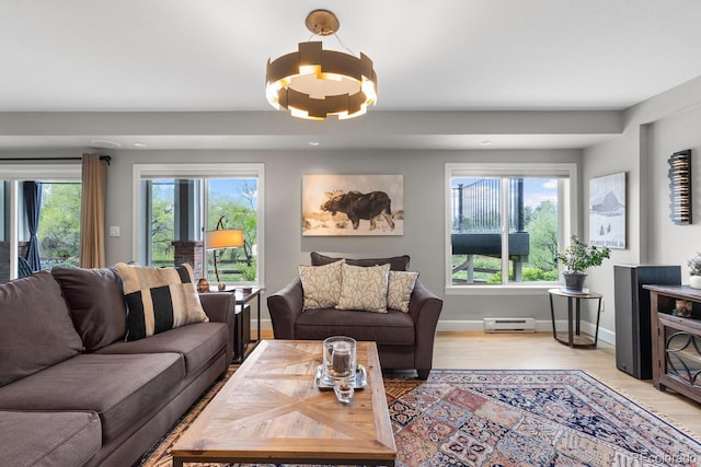 living area featuring a baseboard radiator, light wood finished floors, baseboards, recessed lighting, and a chandelier