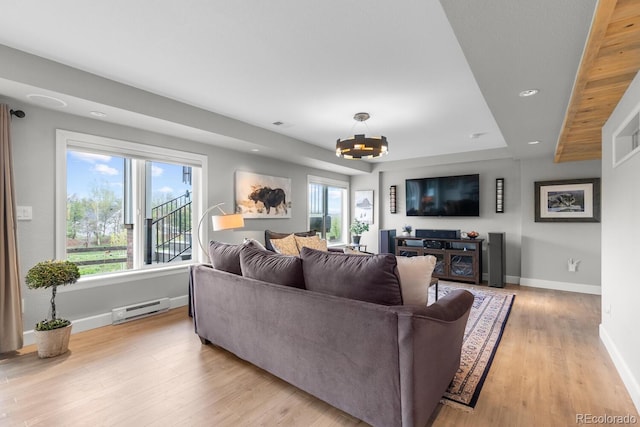 living room featuring a baseboard heating unit, light wood-style flooring, baseboards, a chandelier, and recessed lighting