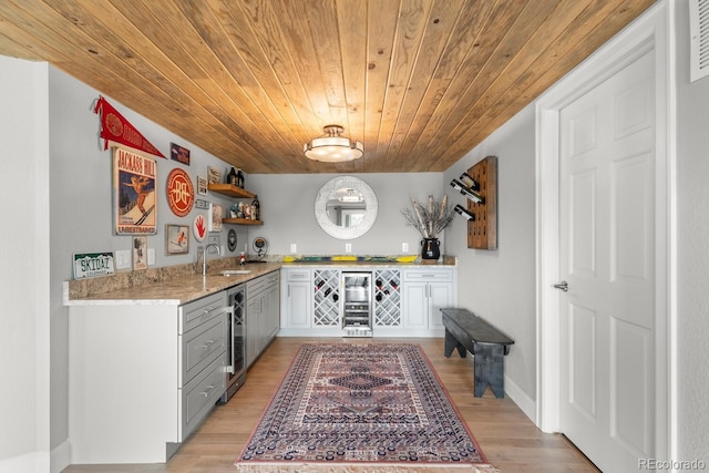 kitchen with wooden ceiling, wine cooler, open shelves, light wood-type flooring, and a sink