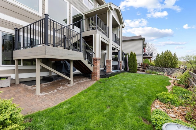 back of house featuring stairway, a yard, and a patio area