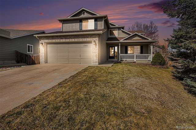 traditional-style house featuring brick siding, a porch, a front yard, driveway, and an attached garage