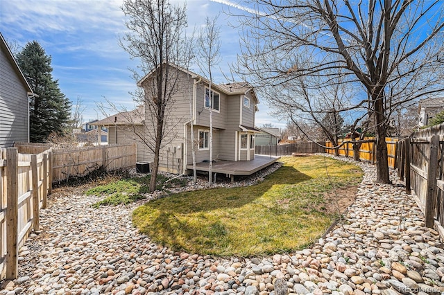 back of property featuring a fenced backyard, central AC unit, a wooden deck, and a yard