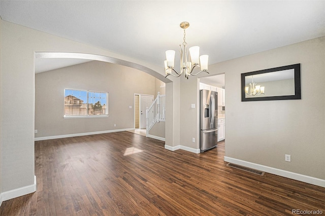 empty room featuring baseboards, visible vents, dark wood finished floors, vaulted ceiling, and a chandelier