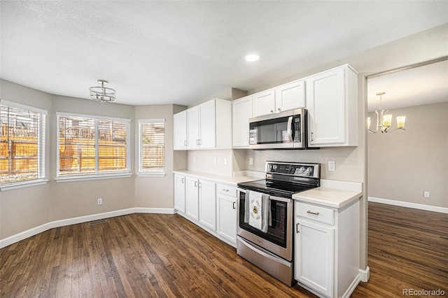 kitchen with baseboards, light countertops, an inviting chandelier, stainless steel appliances, and dark wood-style flooring