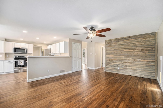 unfurnished living room featuring a ceiling fan, visible vents, baseboards, recessed lighting, and dark wood-type flooring