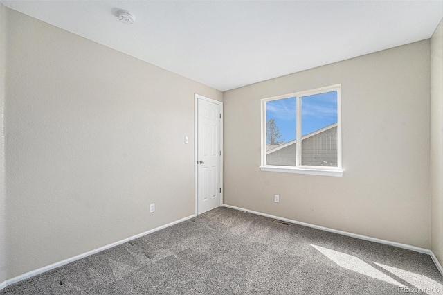 carpeted empty room with visible vents and baseboards