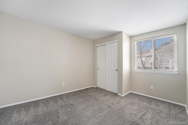 unfurnished bedroom featuring a closet, baseboards, and carpet