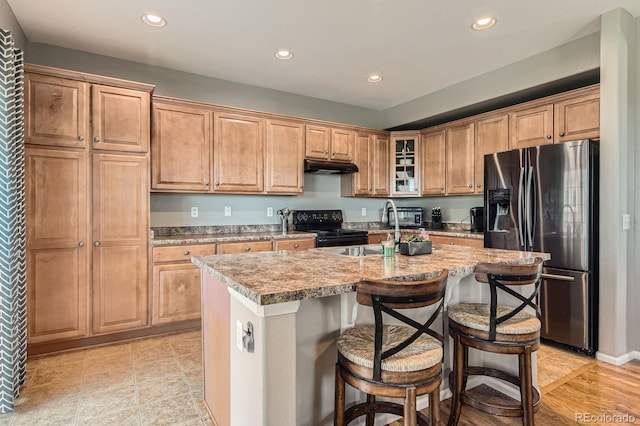 9424 Ridgeline Blvd, Highlands Ranch, CO 80129 - kitchen featuring electric range, stainless steel fridge with ice dispenser, under cabinet range hood, recessed lighting, and a kitchen island with sink