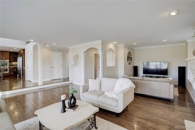 living room featuring crown molding, wood-type flooring, and decorative columns