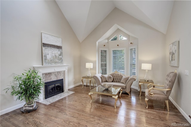 living room with high vaulted ceiling, hardwood / wood-style floors, and a fireplace