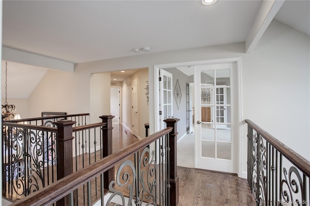 hallway with an inviting chandelier, wood-type flooring, vaulted ceiling, and french doors