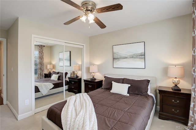 bedroom featuring ceiling fan, light carpet, and a closet