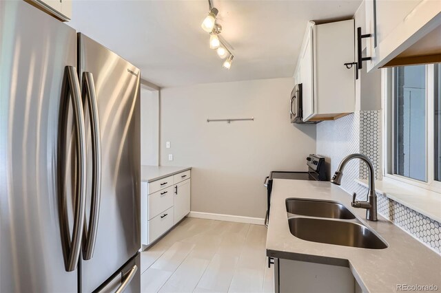 3075 Fairfax St, Denver, CO 80207 - kitchen with white cabinets, appliances with stainless steel finishes, tasteful backsplash, and a sink