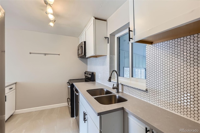 3075 Fairfax St, Denver, CO 80207 - kitchen featuring a sink, decorative backsplash, stainless steel appliances, baseboards, and white cabinetry