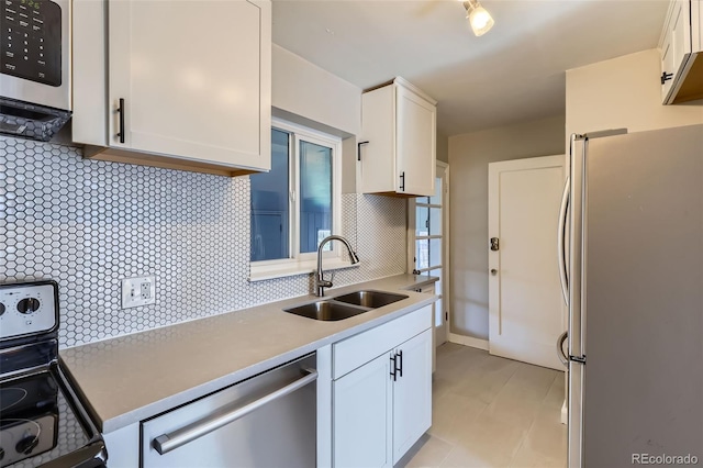 3075 Fairfax St, Denver, CO 80207 - kitchen with a sink, backsplash, white cabinetry, light countertops, and appliances with stainless steel finishes