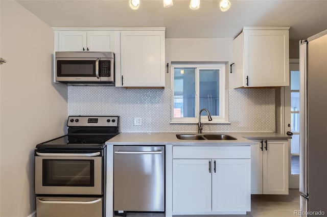 3075 Fairfax St, Denver, CO 80207 - kitchen with a sink, white cabinetry, appliances with stainless steel finishes, and tasteful backsplash