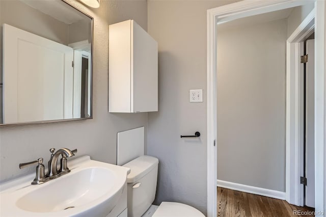 3075 Fairfax St, Denver, CO 80207 - half bathroom featuring wood finished floors, vanity, and toilet