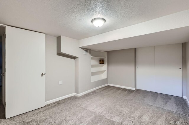 3075 Fairfax St, Denver, CO 80207 - finished basement featuring visible vents, built in features, baseboards, a textured ceiling, and carpet flooring