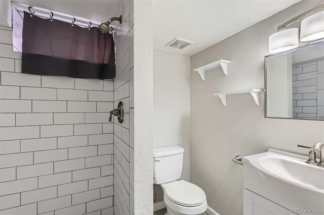 3075 Fairfax St, Denver, CO 80207 - full bath with visible vents, tiled shower, vanity, and toilet