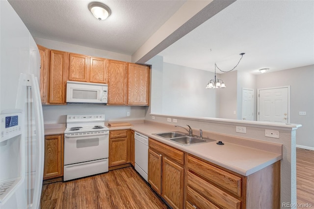 8237 W 54th Ave Unit 2, Arvada, CO 80002 - kitchen with white appliances, a peninsula, wood finished floors, light countertops, and a chandelier