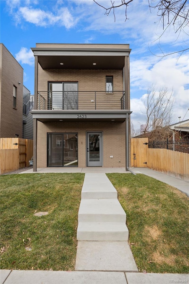 view of front of house featuring a patio area, a balcony, and a front yard