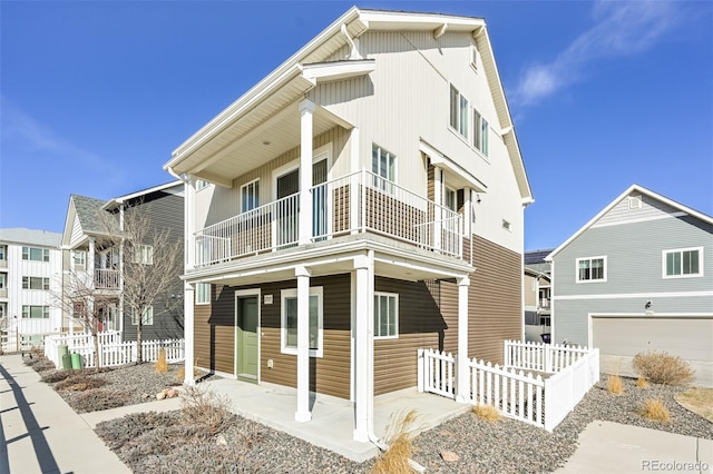 view of front of property with a balcony, fence, and a garage