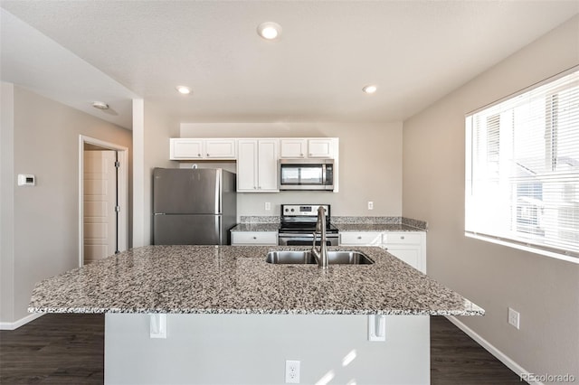 kitchen with a breakfast bar, white cabinets, and appliances with stainless steel finishes