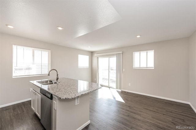 kitchen featuring a sink, dishwasher, dark wood-style floors, and an island with sink