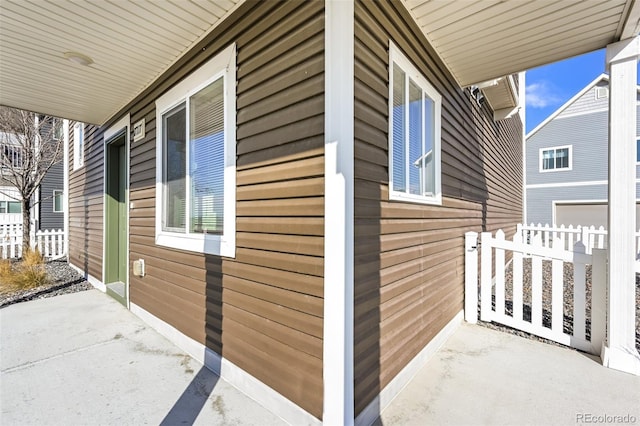 view of property exterior with fence and covered porch