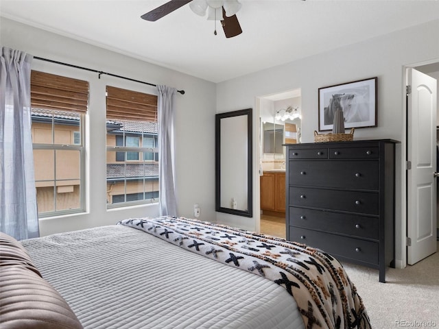 bedroom featuring ceiling fan, connected bathroom, and light colored carpet