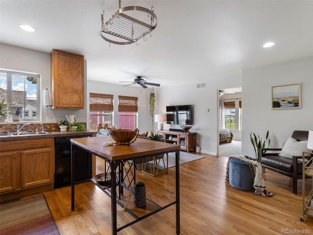 kitchen with ceiling fan, sink, a textured ceiling, light hardwood / wood-style flooring, and dishwasher