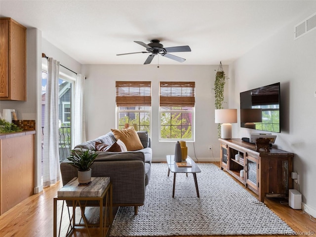 living room with a healthy amount of sunlight, ceiling fan, and light hardwood / wood-style floors