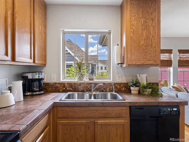 kitchen with black appliances, sink, and tile counters