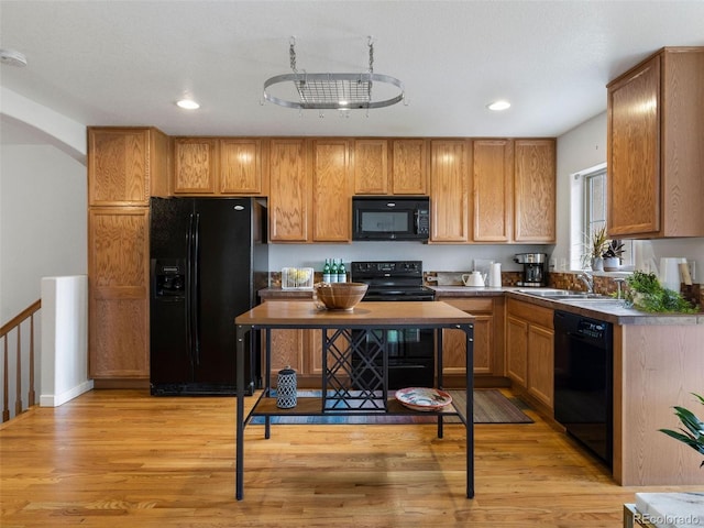 kitchen featuring light wood-type flooring, sink, and black appliances