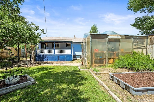 3306 S Logan St, Englewood, CO 80113 - rear view of house with a greenhouse, an outbuilding, and a garden