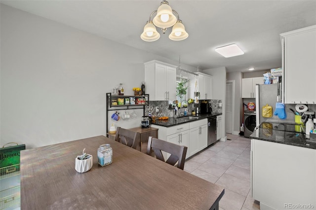 1944 Carmel Dr, Colorado Springs, CO 80910 - kitchen featuring dishwasher, washer / clothes dryer, decorative backsplash, white cabinets, and light tile patterned floors
