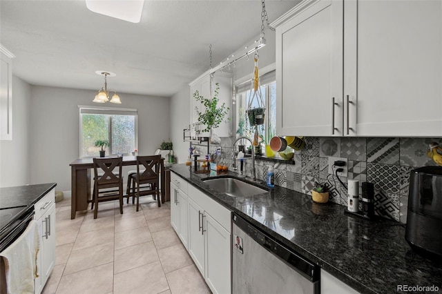 1944 Carmel Dr, Colorado Springs, CO 80910 - kitchen featuring stainless steel dishwasher, backsplash, white cabinets, and dark stone countertops
