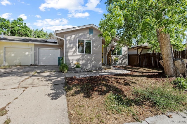 1944 Carmel Dr, Colorado Springs, CO 80910 - ranch-style house with a garage, driveway, and roof mounted solar panels