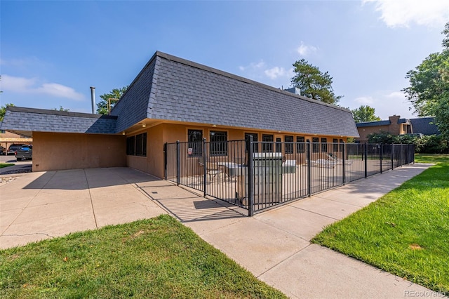 view of front of house featuring a front lawn and a patio area