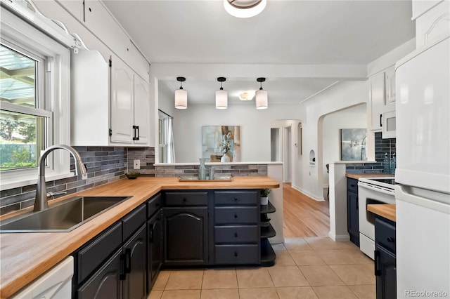 kitchen with a sink, white cabinets, white appliances, and butcher block countertops