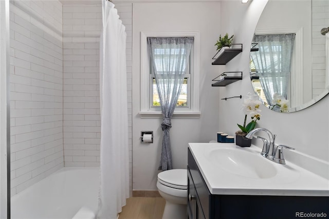 bathroom featuring vanity, toilet, baseboards, wood finished floors, and shower / tub combo